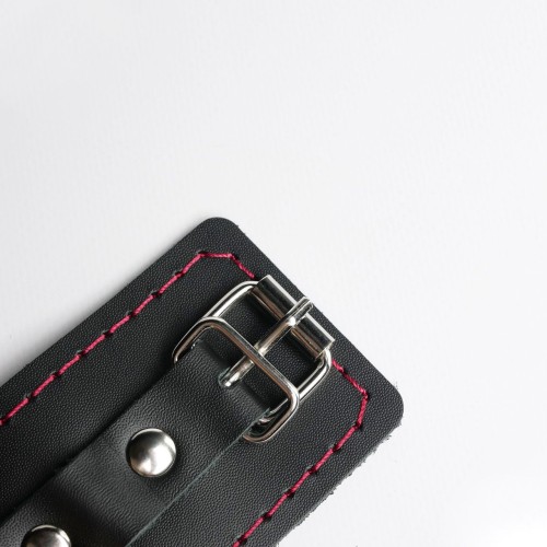 Черные кожаные наручники с красной строчкой